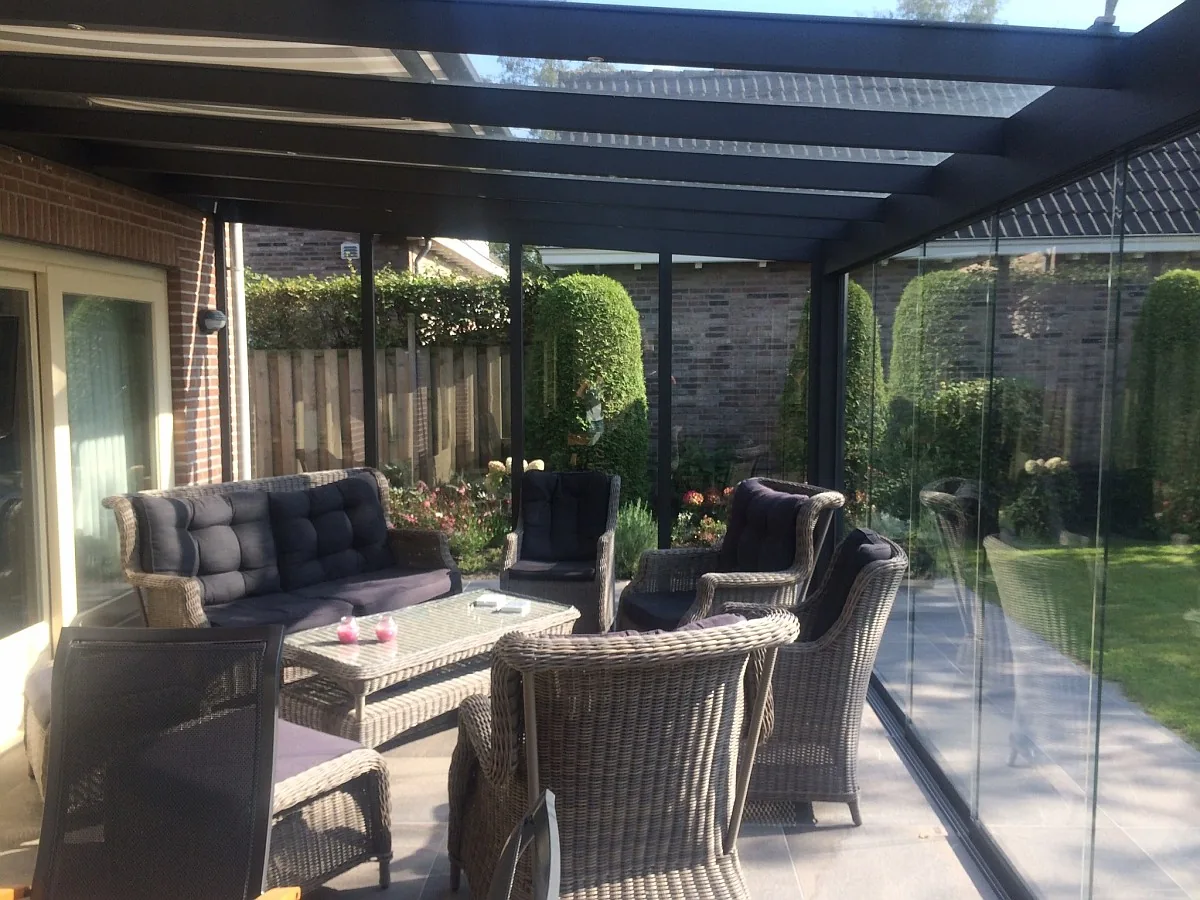 Terrassenüberdachung mit Glaswänden und Loungemöbeln
