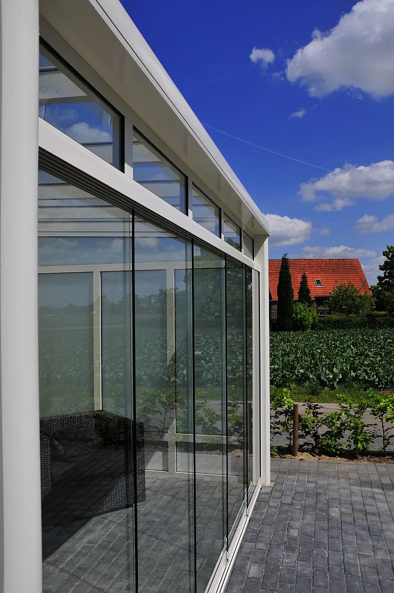 Glasschiebewand an einem Terrassendach mit Blick auf Felder