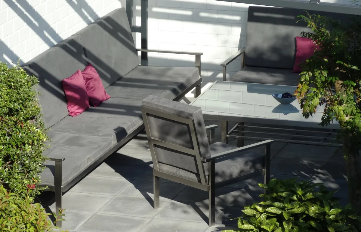 Loungemöbel mit Metallgestell und grauen Polstern auf einer Terrasse