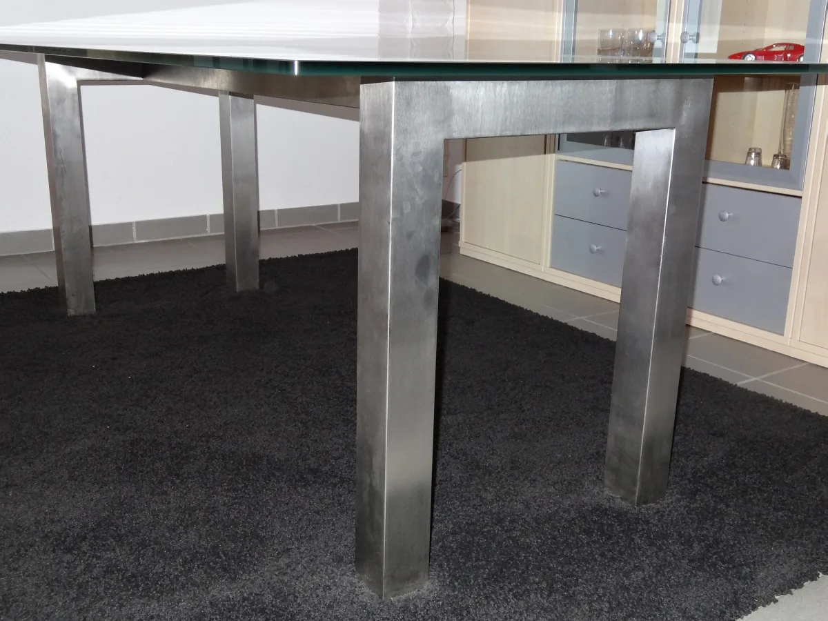 Tischgestell aus Edelstahl mit Glasplatte in einem Wohnraum