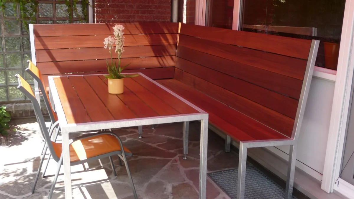 Sitzgruppe aus Edelstahl mit Holzauflagen auf einer Terrasse