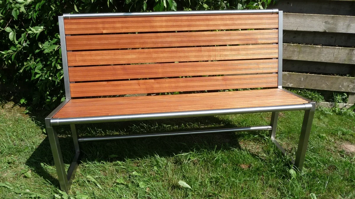 Gartenbank aus Edelstahl mit Holzlatten auf dem Rasen