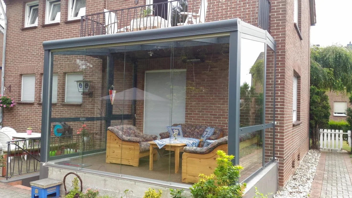 Als Sommergarten geschlossene Terrassenüberdachung mit Schiebeelementen an einem Backsteinhaus
